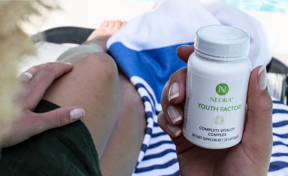 A person holding up a bottle of Youth Factor® Complete Vitality Complex.